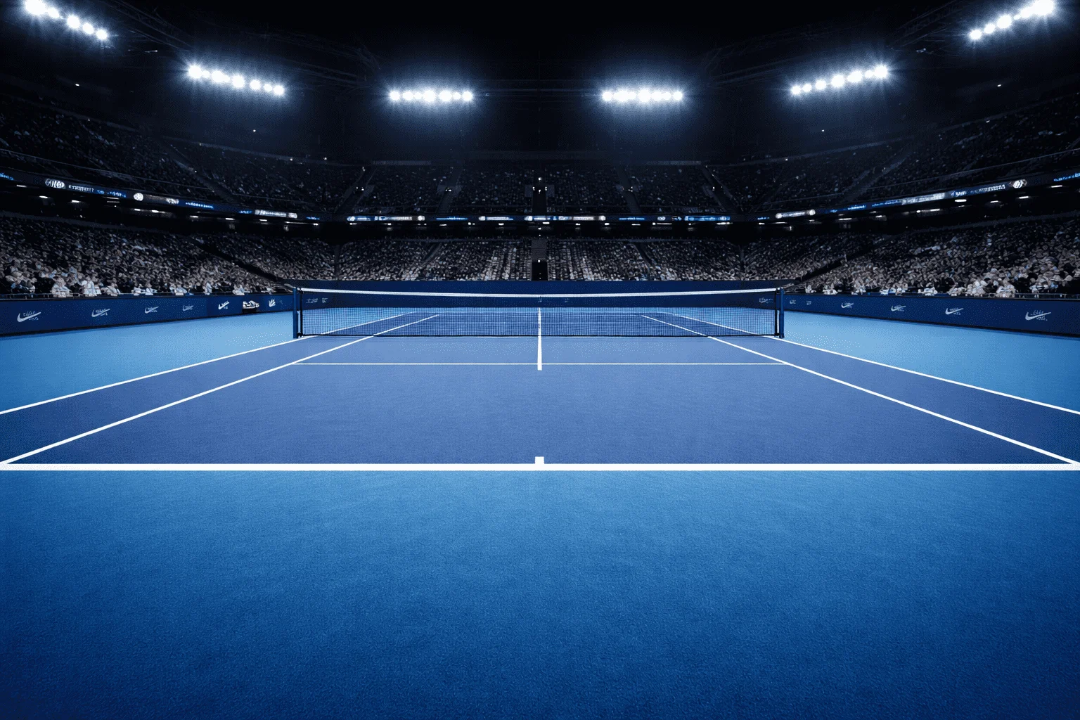 Estádio de ténis com piso duro azul iluminado durante sessão nocturna