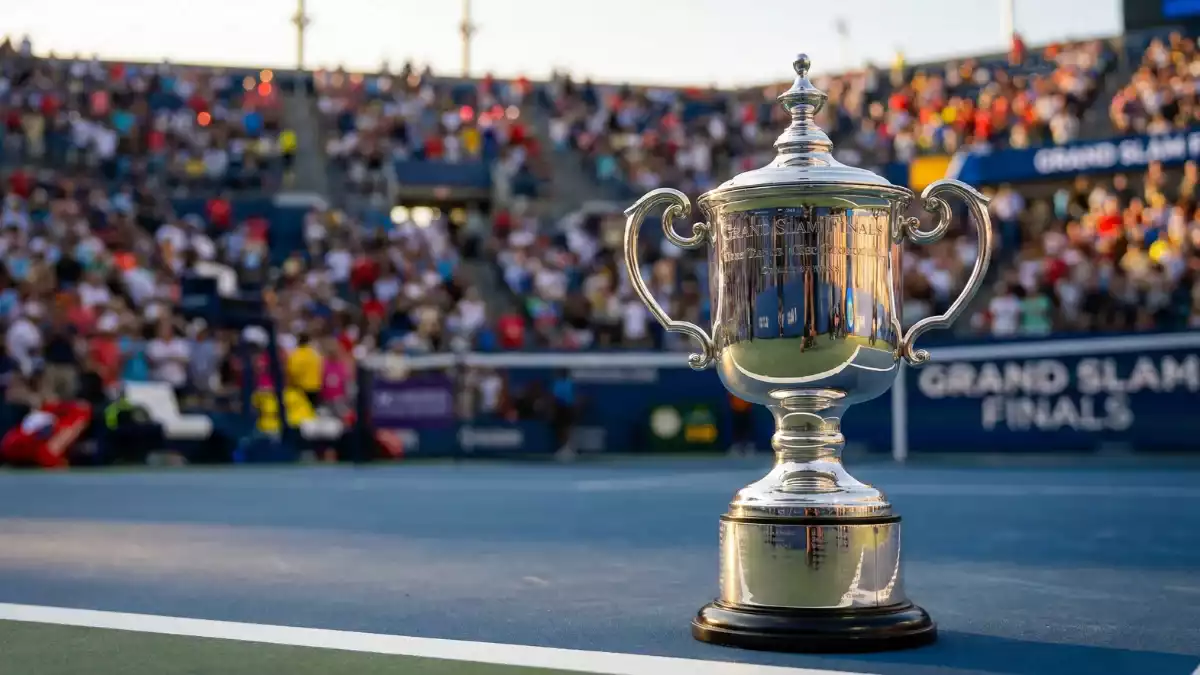 Troféu de Grand Slam brilhante em primeiro plano com estádio de ténis lotado ao fundo sob luzes dramáticas