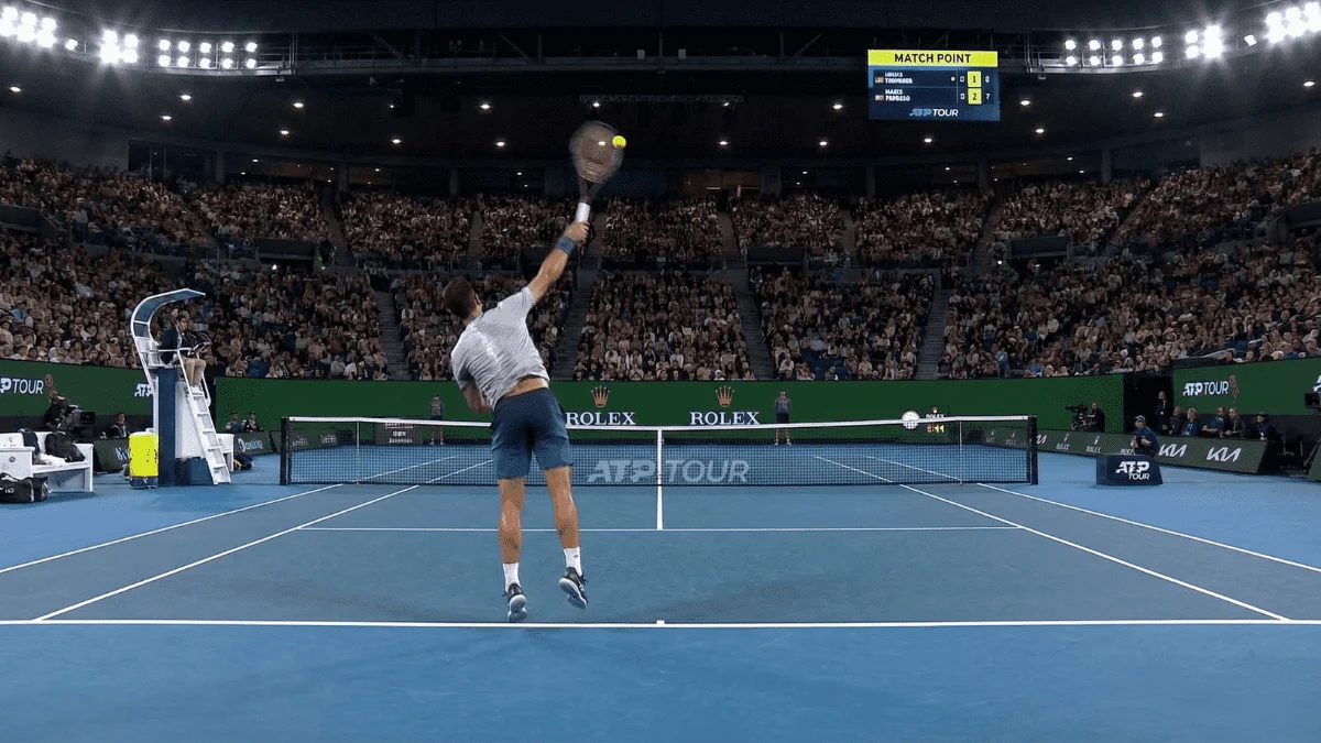 Momento intenso de partida de ténis ao vivo num estádio lotado com jogador a servir
